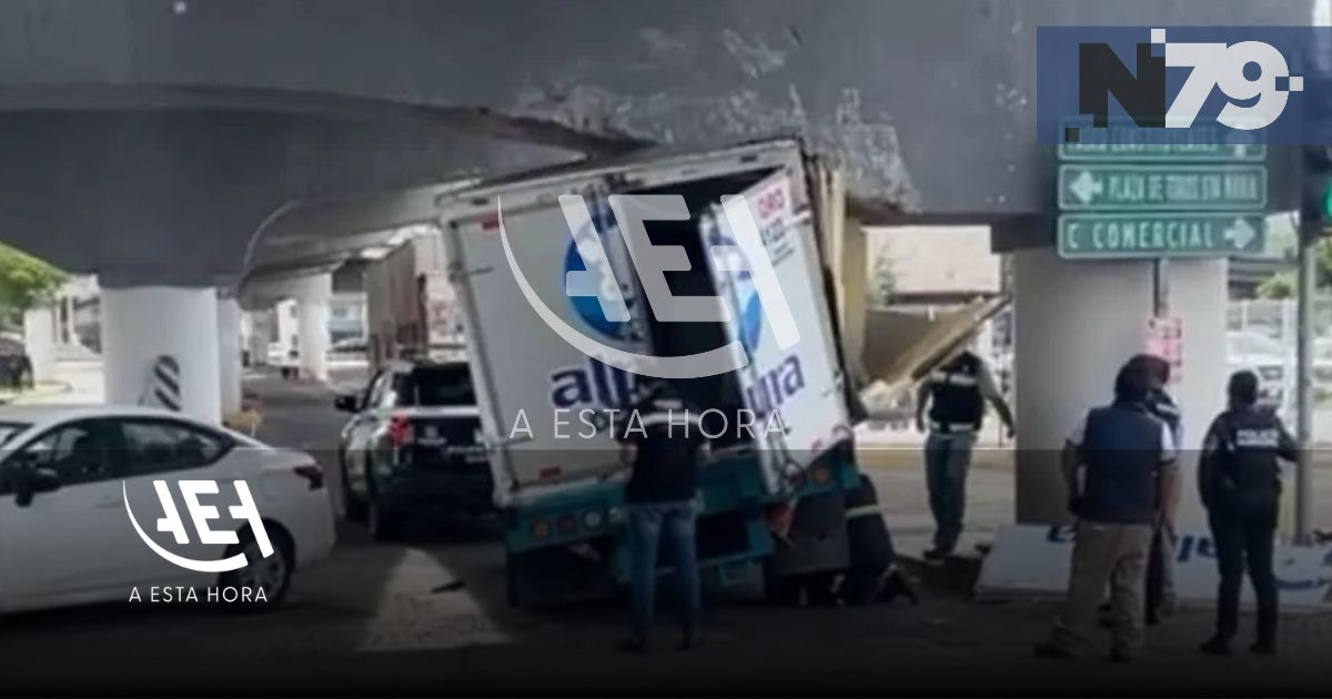 Camioneta de Alpura queda atorada bajo puente
